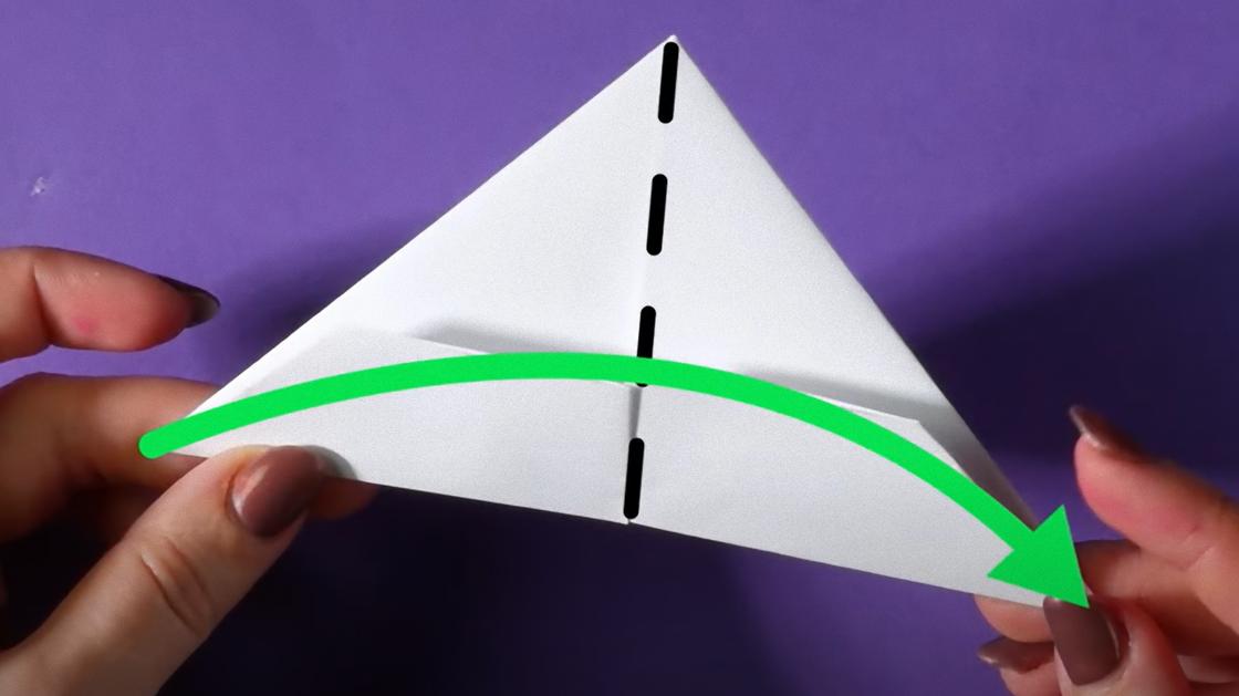 Треугольник с пунктирной вертикальной линией и зеленой стрелкой деражат в руках