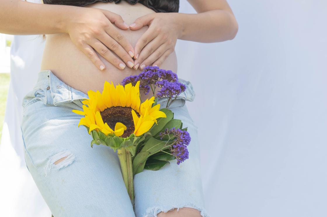 Беременная женщина держит цветы