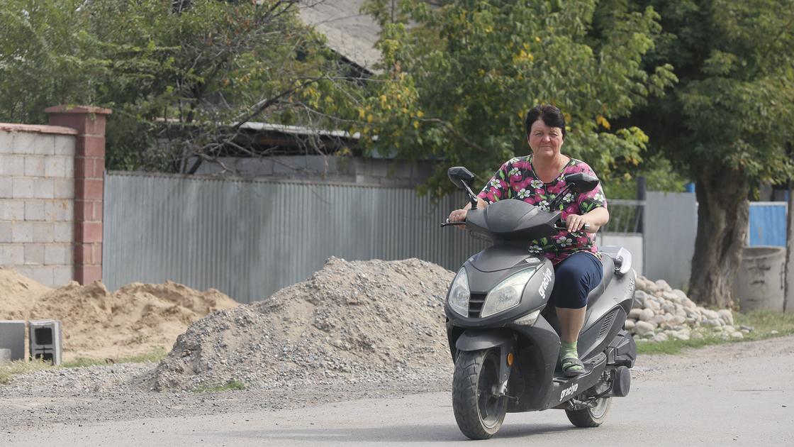 Женщина едет на мотоцикле