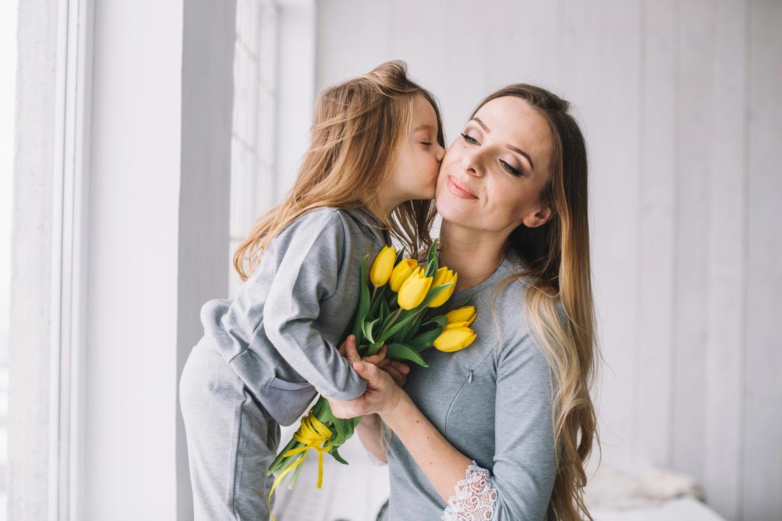Девочка дарит маме цветы