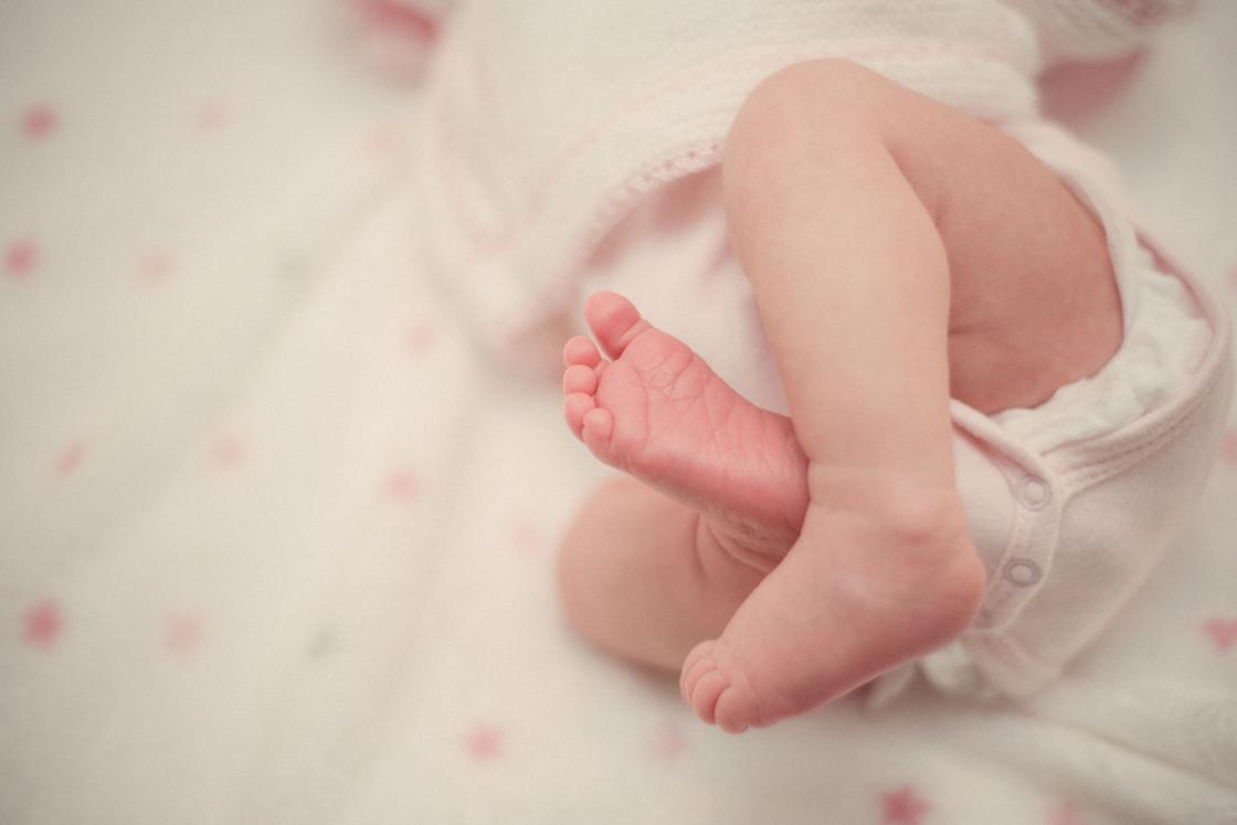 Новорожденный ребенок в подгузнике и боди