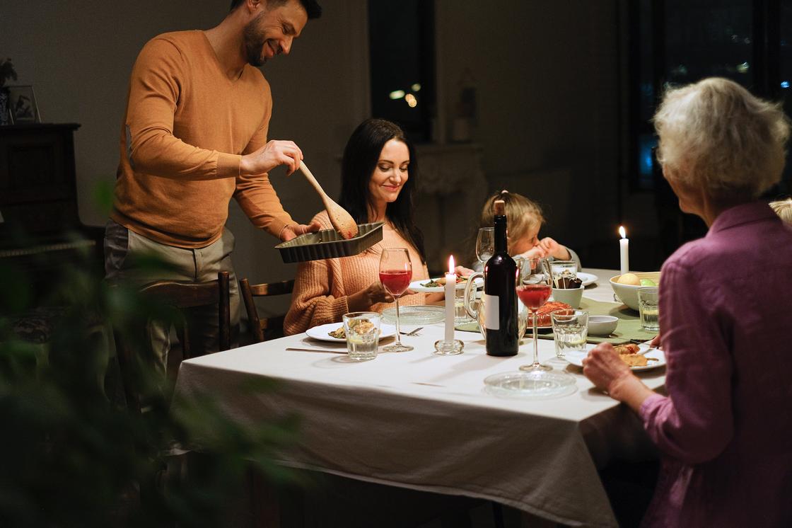 Семья ужинает на столом при свечах