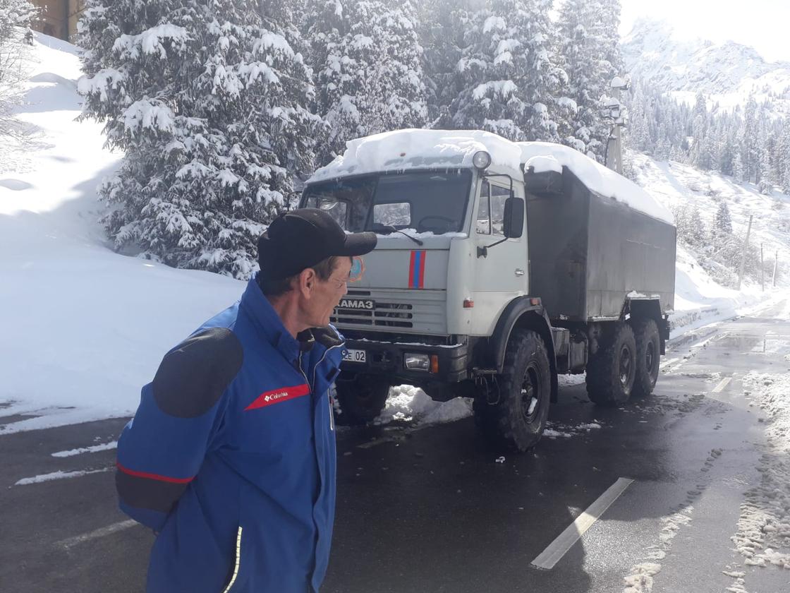 Сотрудник ДЧС возле грузовика в горах