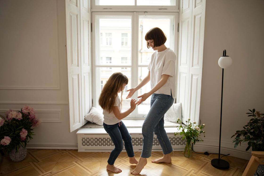 Женщина учит девочку танцевать