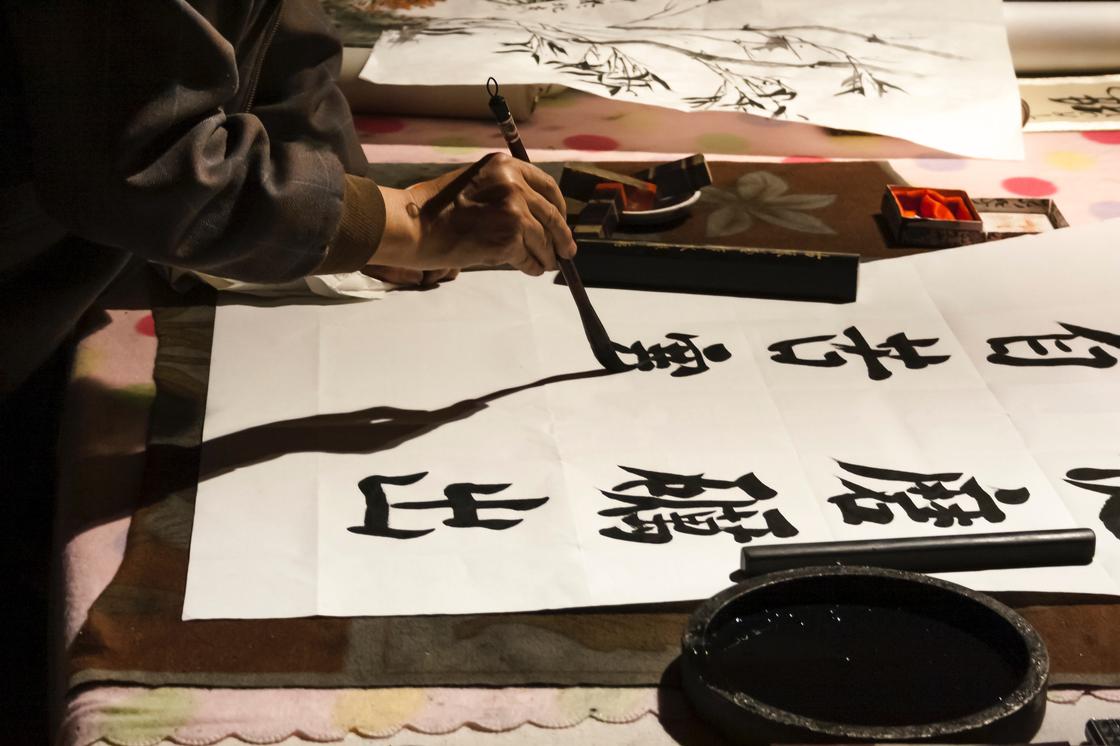 Человек пишет китайские иероглифы