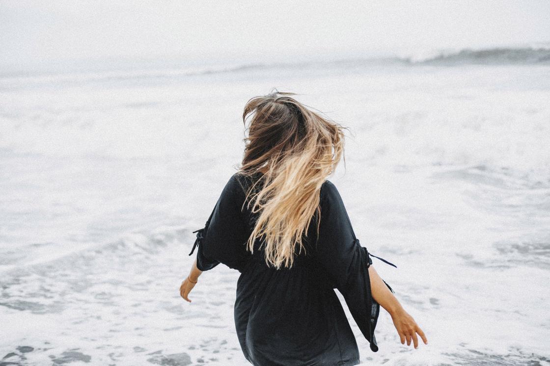 Девушка с длинными волосами на фоне моря