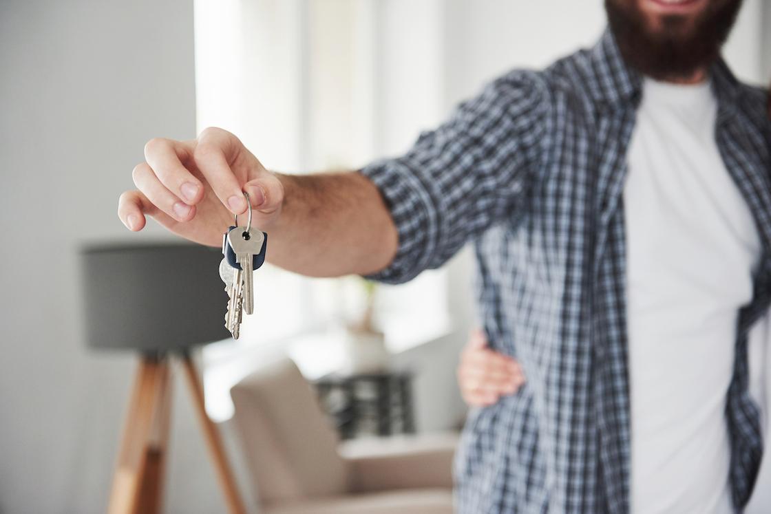 Мужчина держит ключи от квартиры