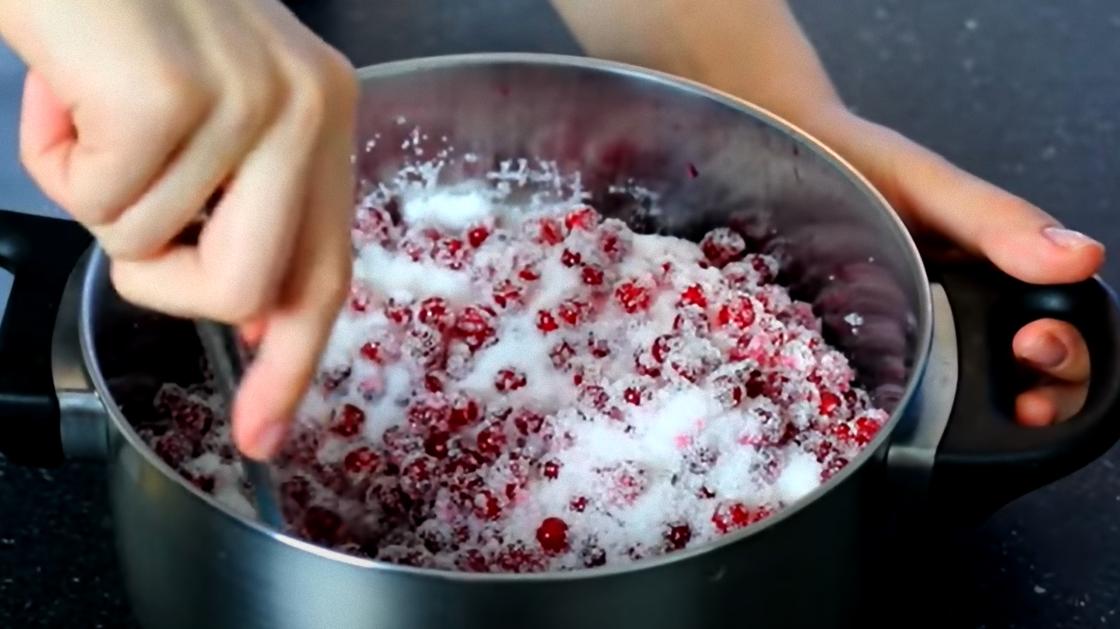 В кастрюле смешивают красную смородину с сахаром В кастрюле смешивают красную смородину с сахаром