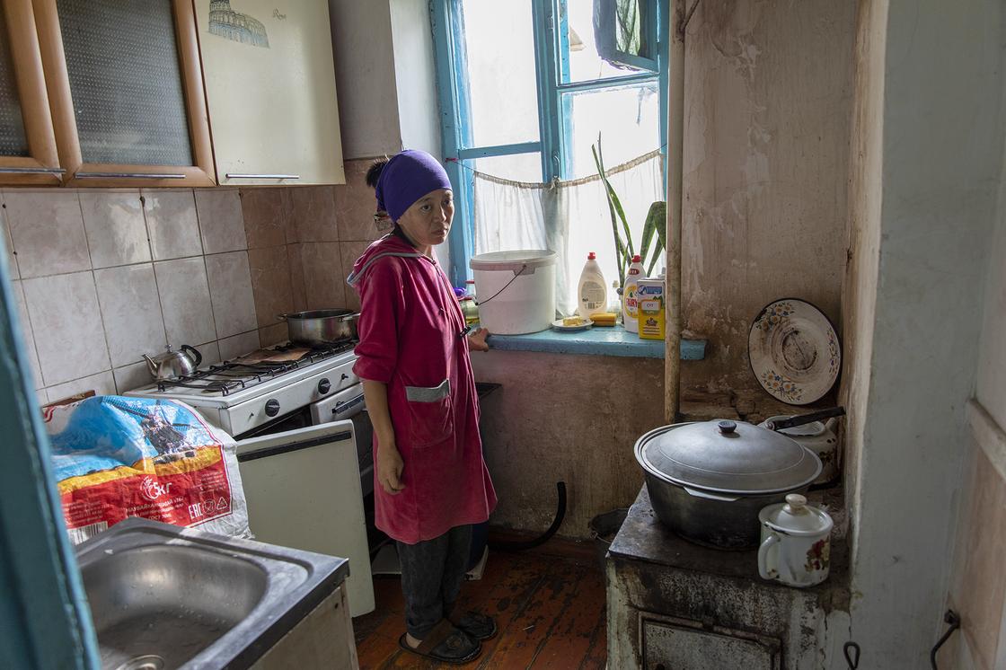 Женщина стоит на кухне в квартире