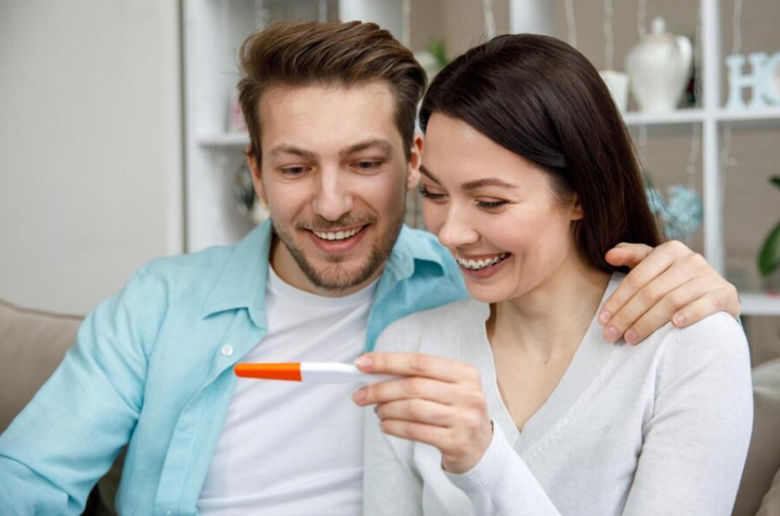 Женщина показывает мужчине тест на беременность