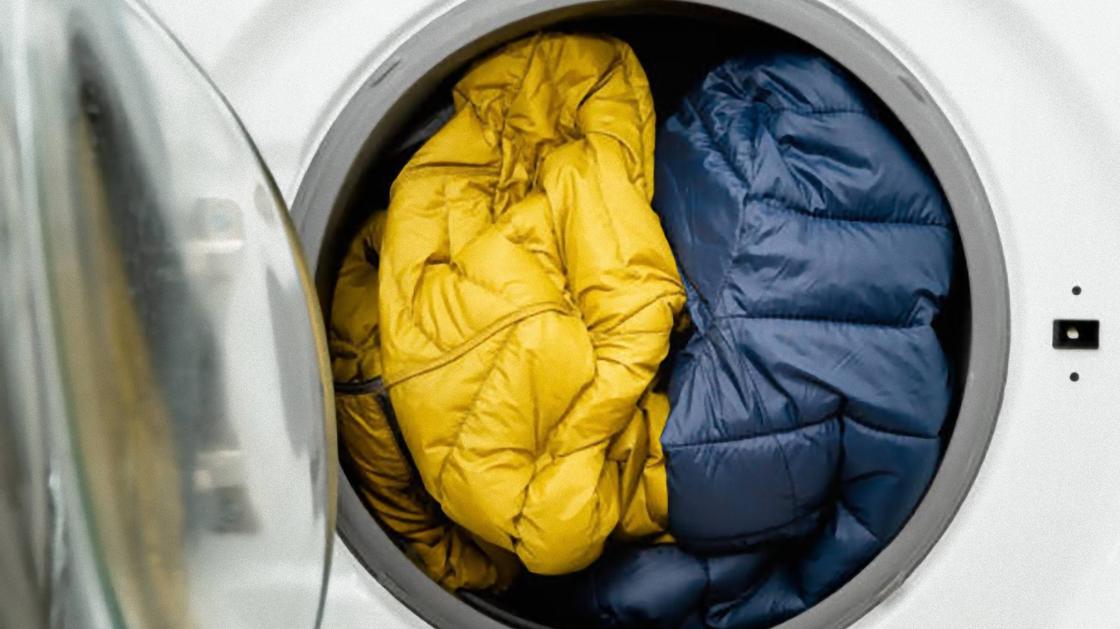 Одежда в стиральной машине синего и желтого цвета