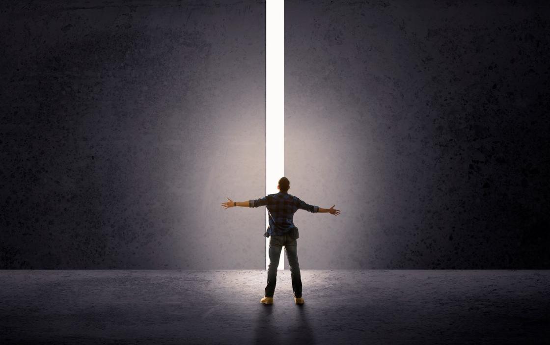 Мужчина стоит перед просветом в стене
