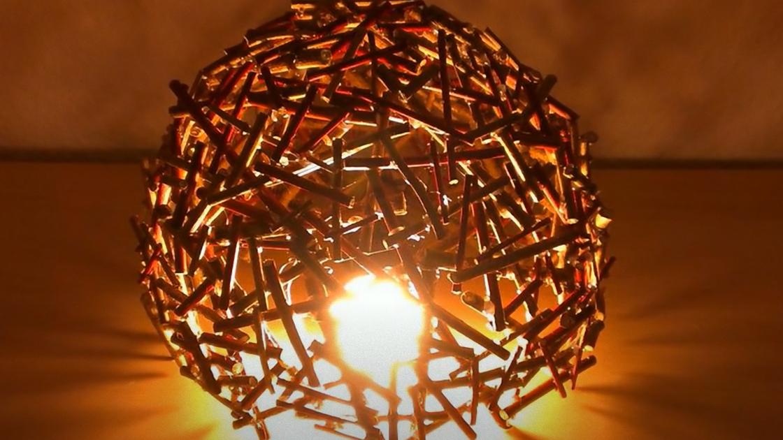 Светильник сделан с деревянных палочек, склеенных между собой. Внутри светится лампочка