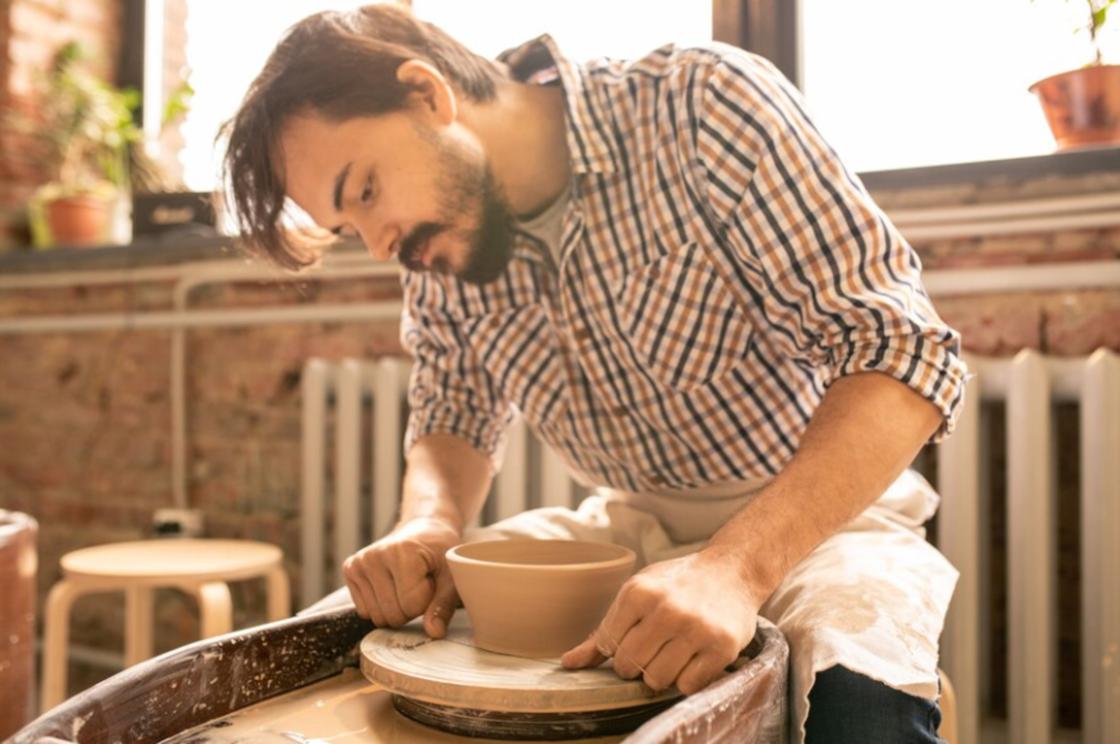 Мужчина лепит посуду из глины