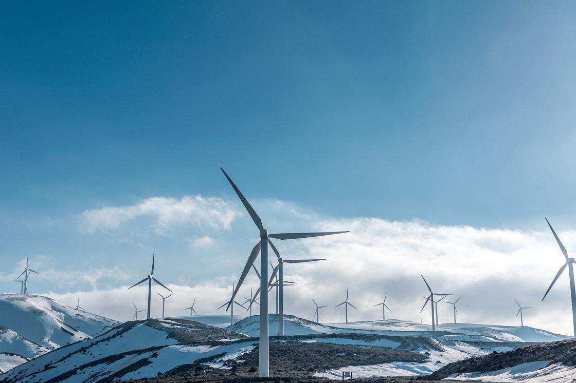 Ветровые электростанции стоят на заснеженных холмах