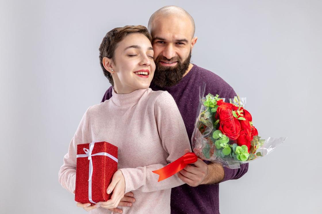 Женщина с подарком, мужчина с цветами в руках