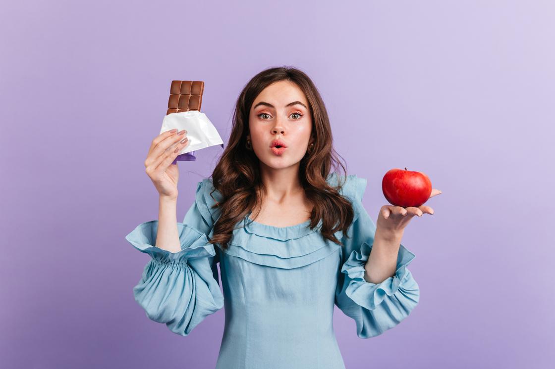 Девушка с шоколадкой и яблоком