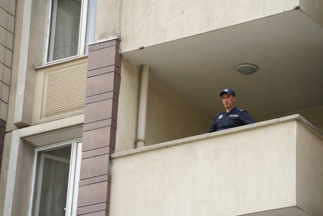 Полицейский на балконе дома, горевшего в Алматы