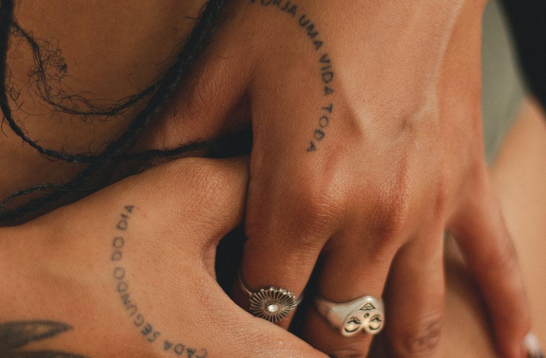 Женские руки с аккуратными тату-надписями на кистях рук