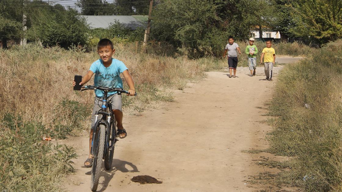 Мальчик  едет на велосипеде