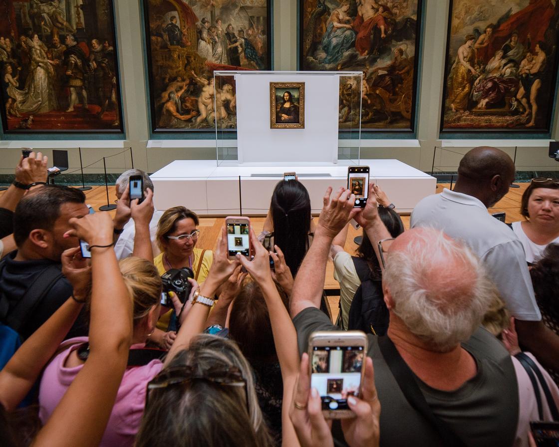 Посетители музея фотографируют картину