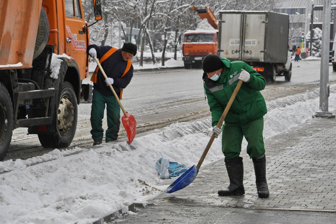 Рабочие убирают снег
