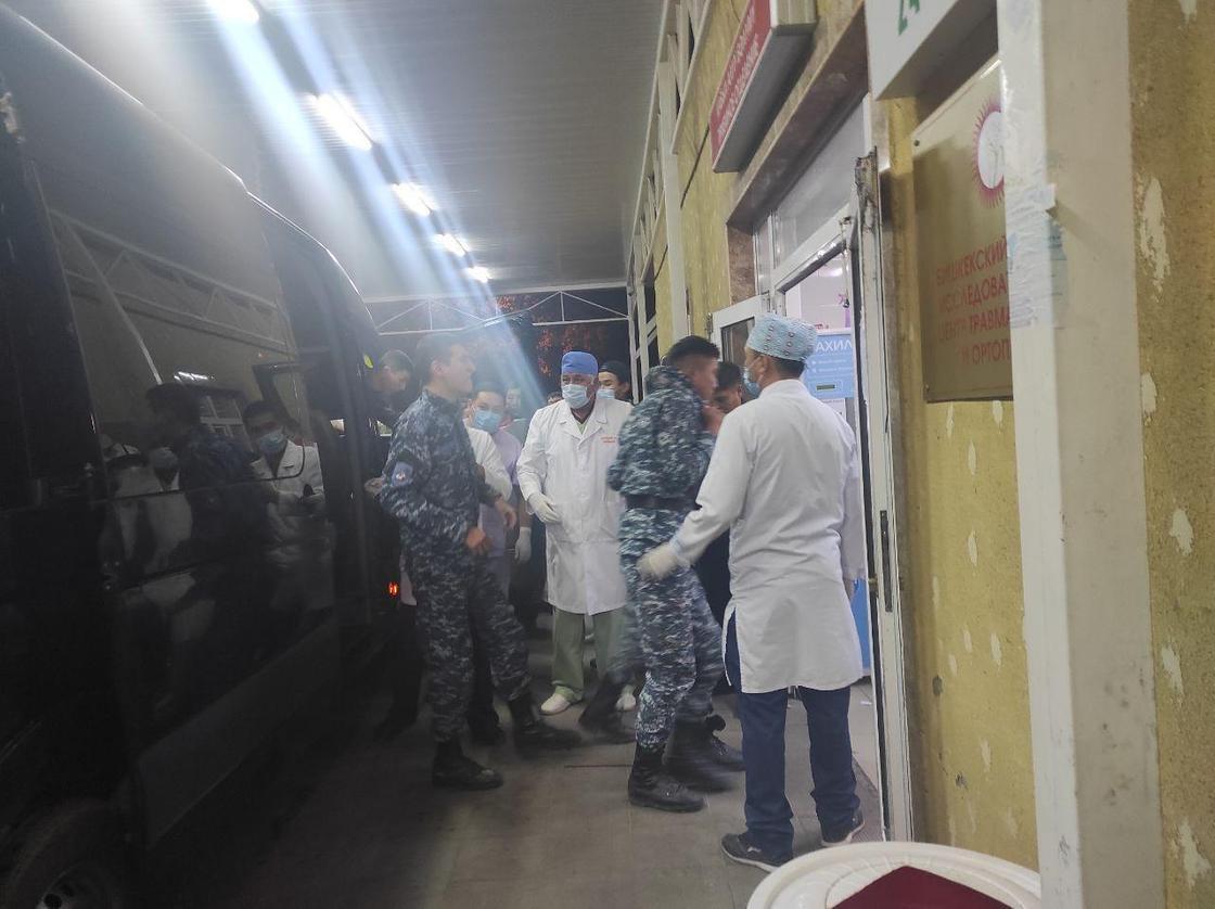 врачи и сотрудники спецназа стоят возле дверей больницы