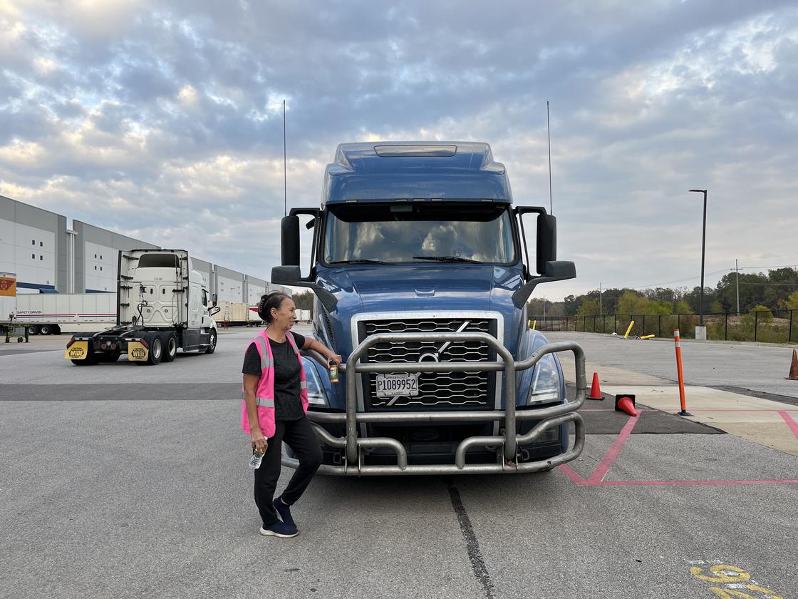 Женщина стоит возле большого грузовика