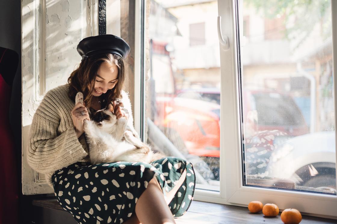 Девушка у окна с котенком