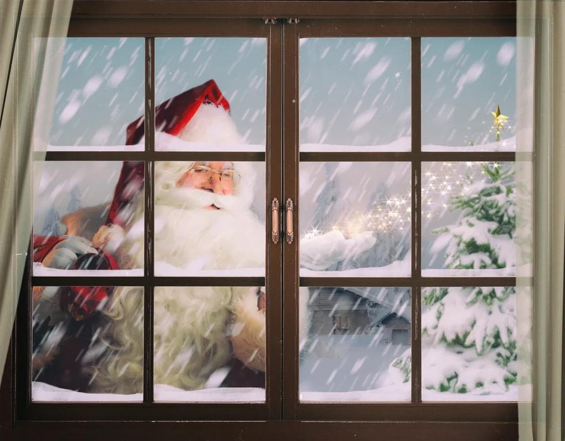 Дед Мороз в снежный день заглядывает в окно дома