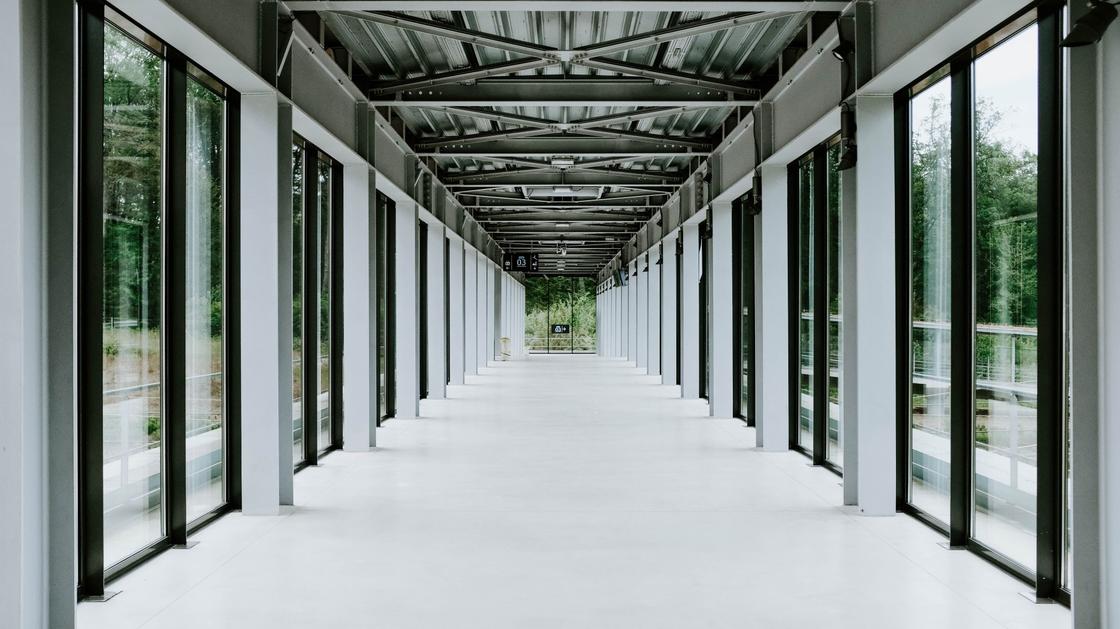 Длинный коридор с пластиковыми окнами с обеих сторон