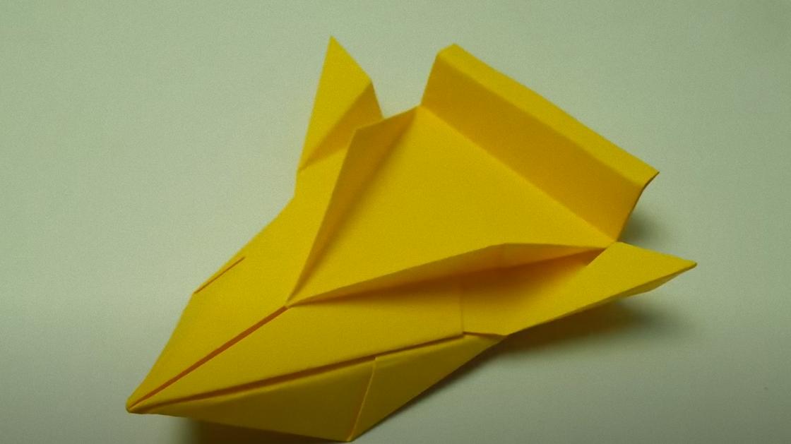 Гоночная машинка сложена из желтой бумаги в технике оригами