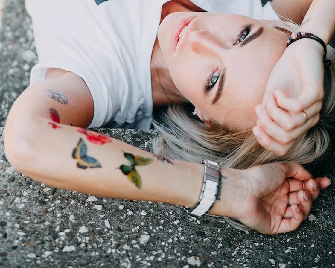 Татуировки в виде цветных бабочек на руке у девушки