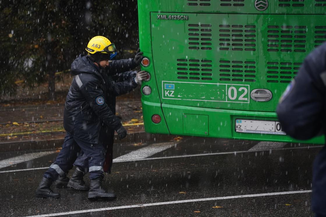 Автобус толкают спасатели