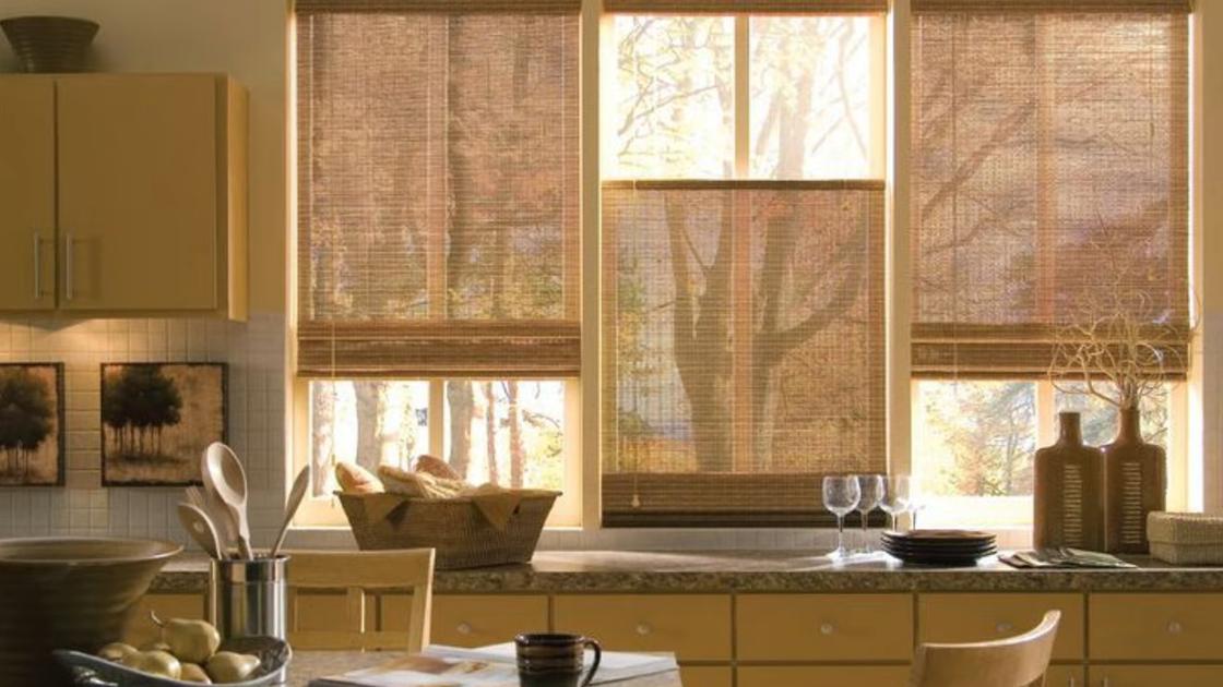 Трехстворчатое кухонное окно оформлено бамбуковыми шторами