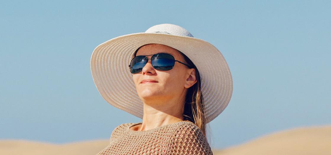 Девушка в широкополой шляпе и солнцезащитных очках