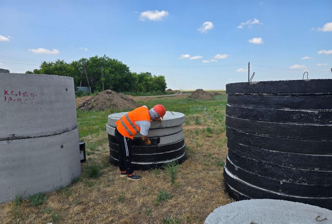 Рабочий красит бетонные кольца