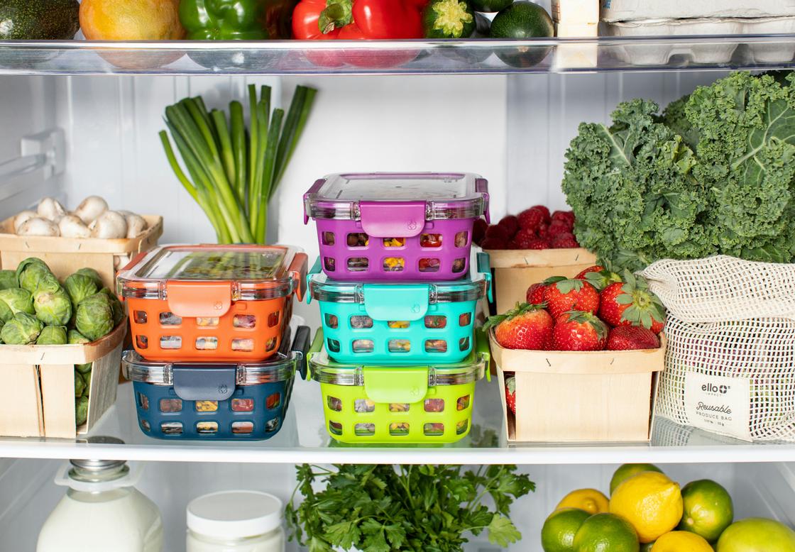 Продукты на полке холодильника в пищевых контейнерах и корзинках