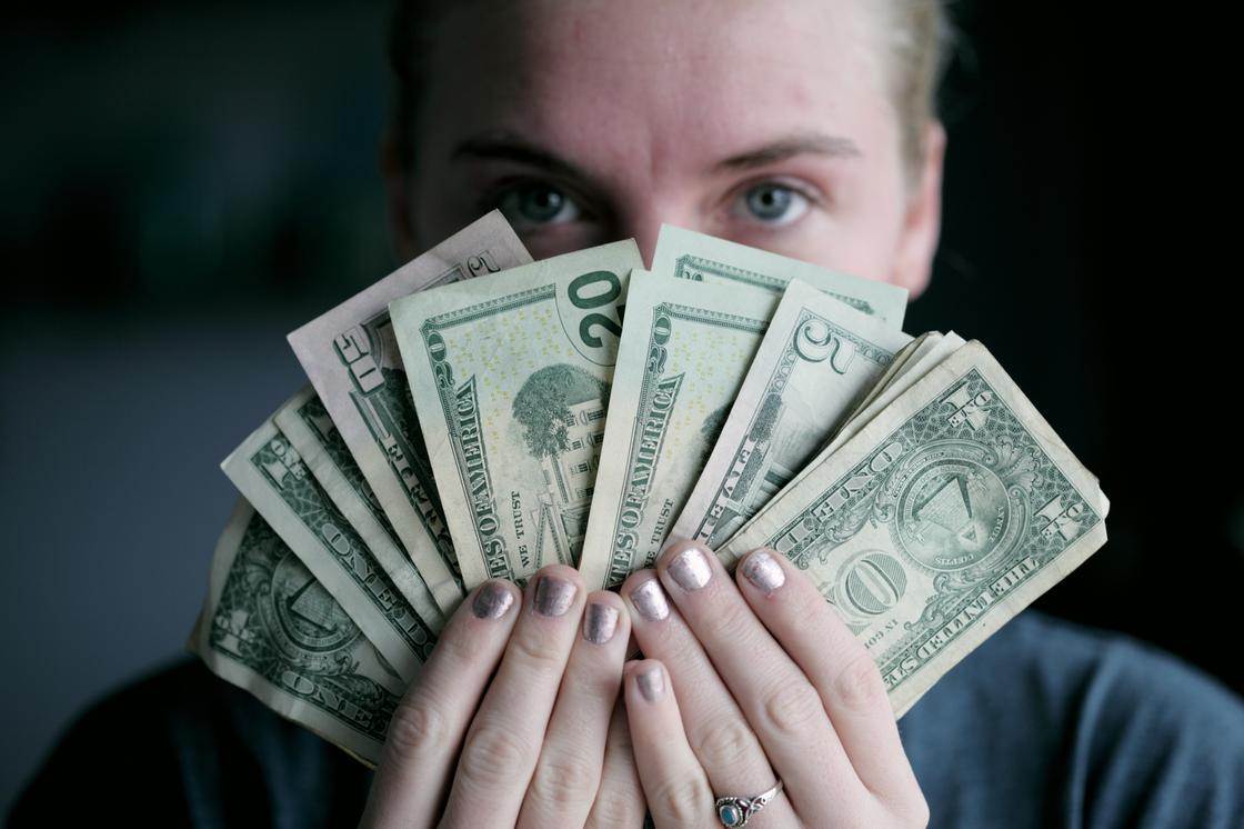 Девушка держит доллары