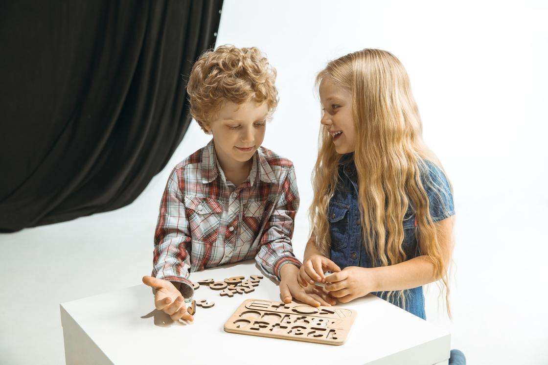 Мальчик и девочка играют в игру с буквами