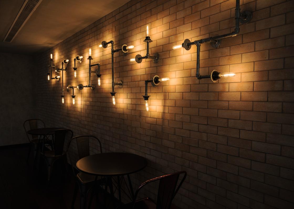 Светильники в виде труб на кирпичной стене