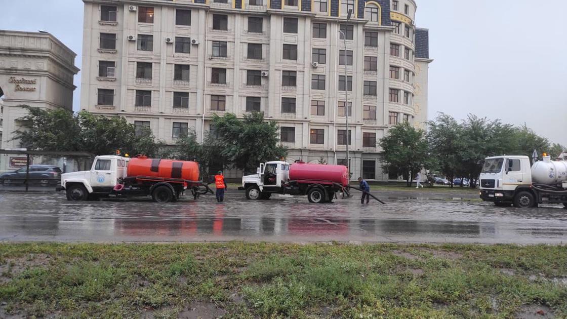 Водовозы откачивают дождевую воду на дороге в Нур-Султане