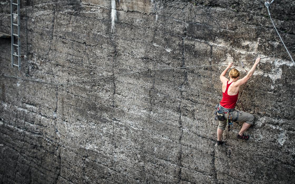 Женщина карабкается по скале