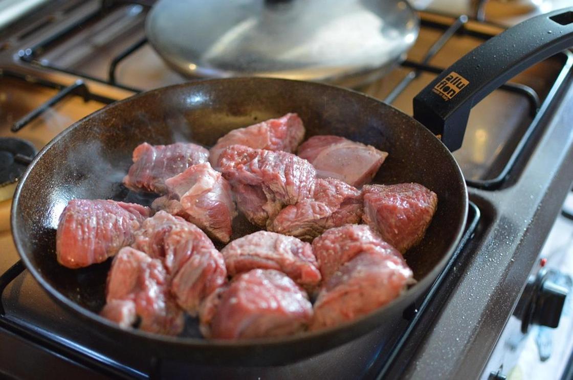 Мясо жарится на сковороде Мясо жарится на сковороде