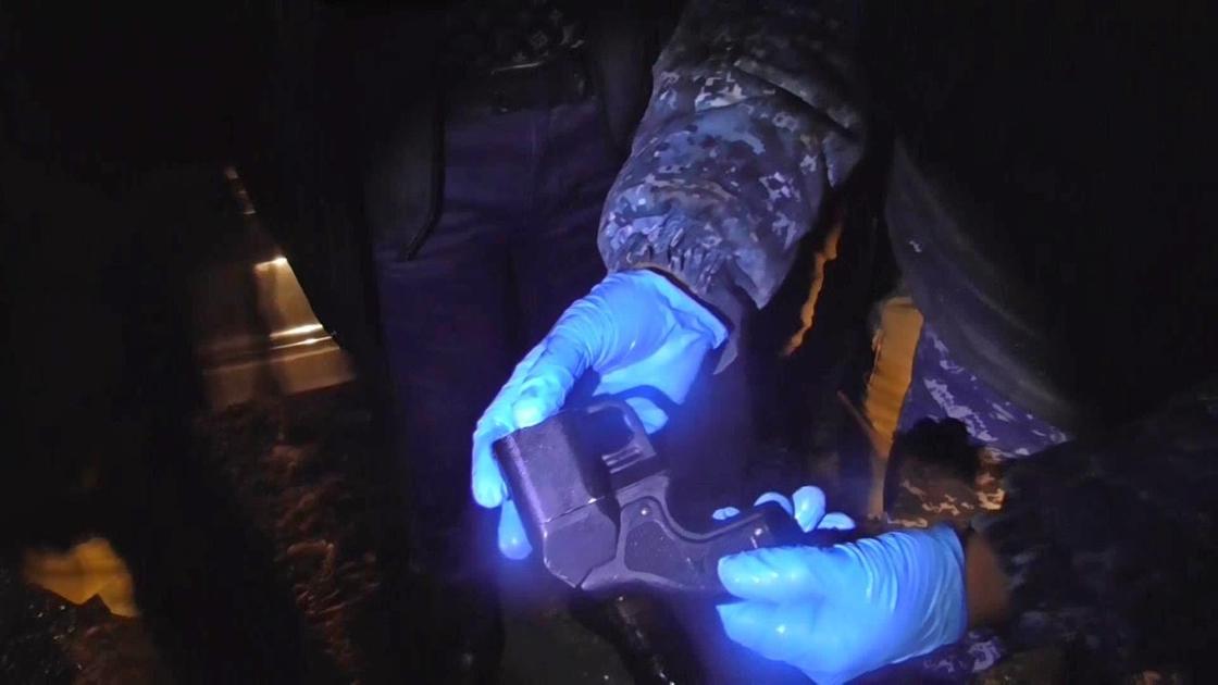 Полицейский держит в руках травматический пистолет