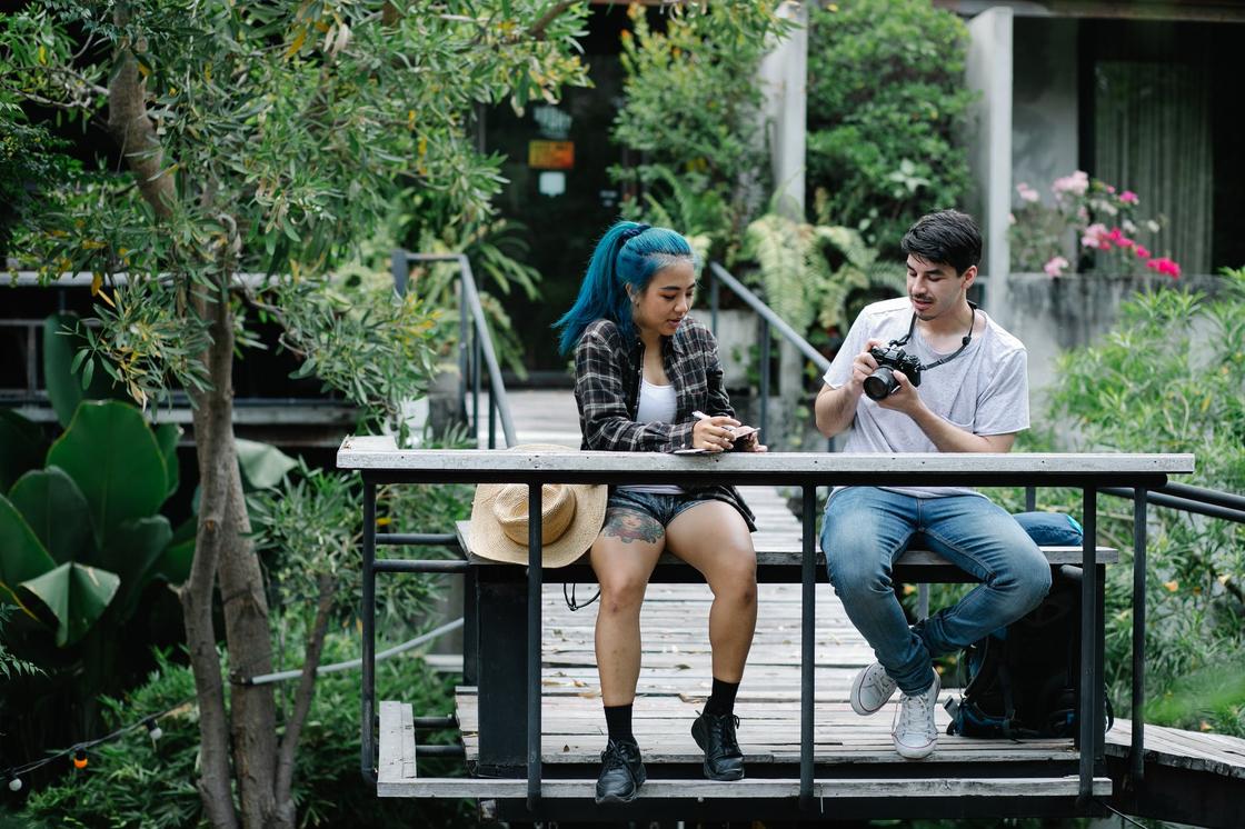 Парень фотографирует девушку с голубыми волосами, сидящую рядом с ним