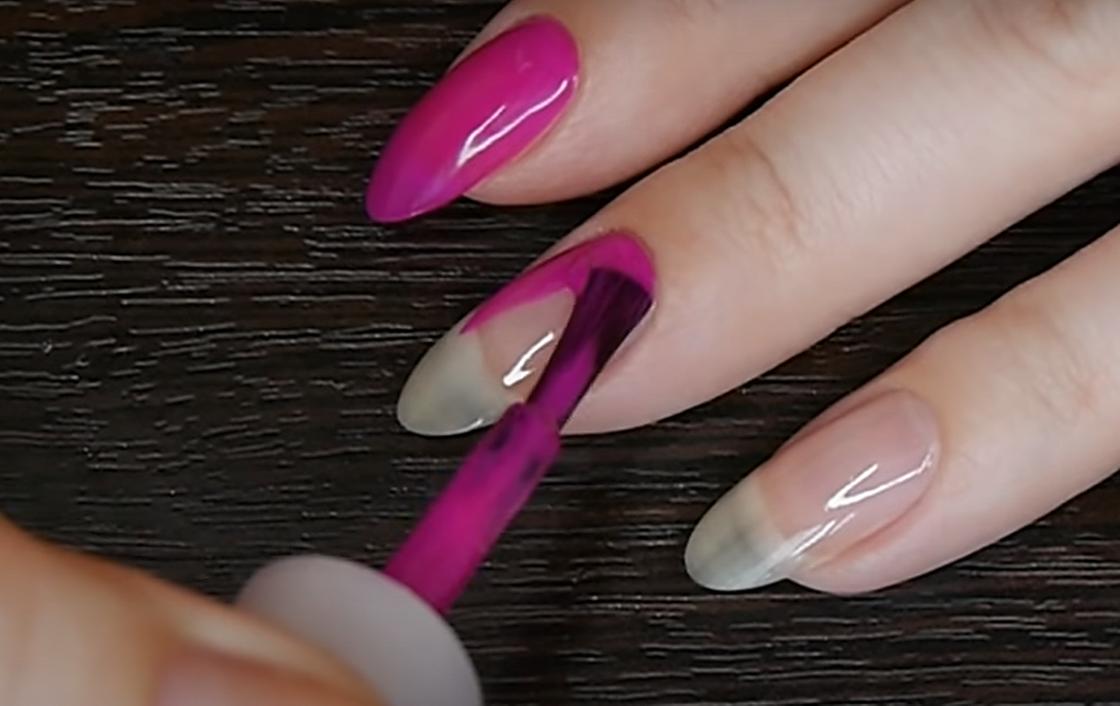 Нанесение розового лака на поверхность овальных ногтей