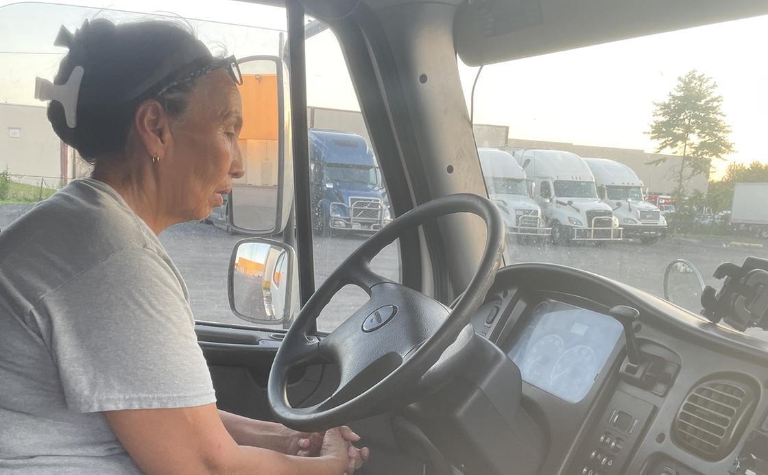 Женщина сидит в кабине грузовика