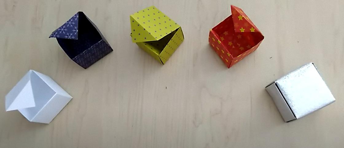 Коробочки с крышкой сделаны из разноцветной бумаги в технике оригами