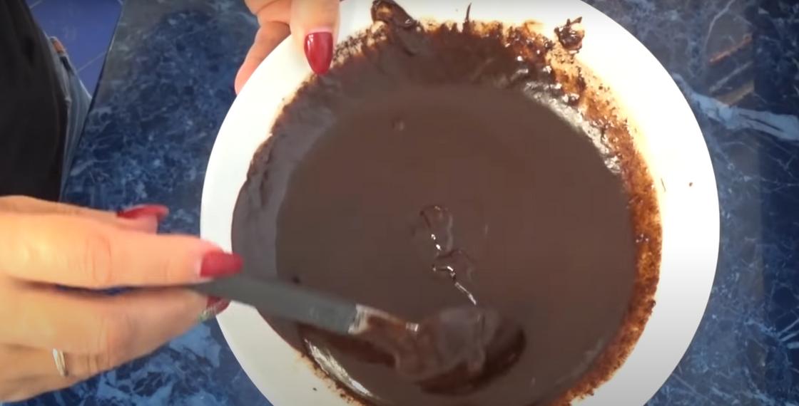 Шоколадный крем для торта в тарелке с ложкой Шоколадный крем для торта в тарелке с ложкой